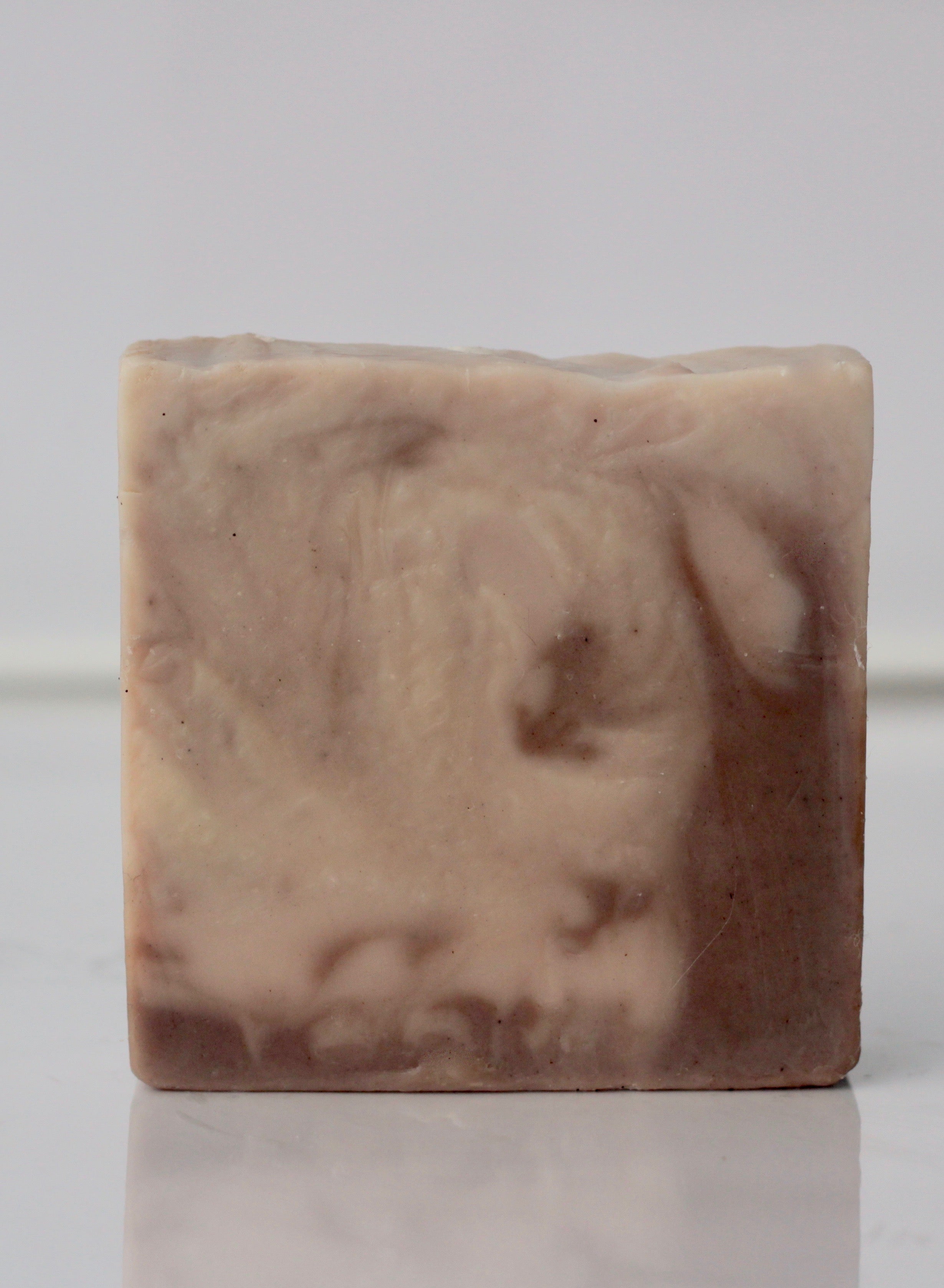 Golden Earth clay soap bar on a natural stone surface